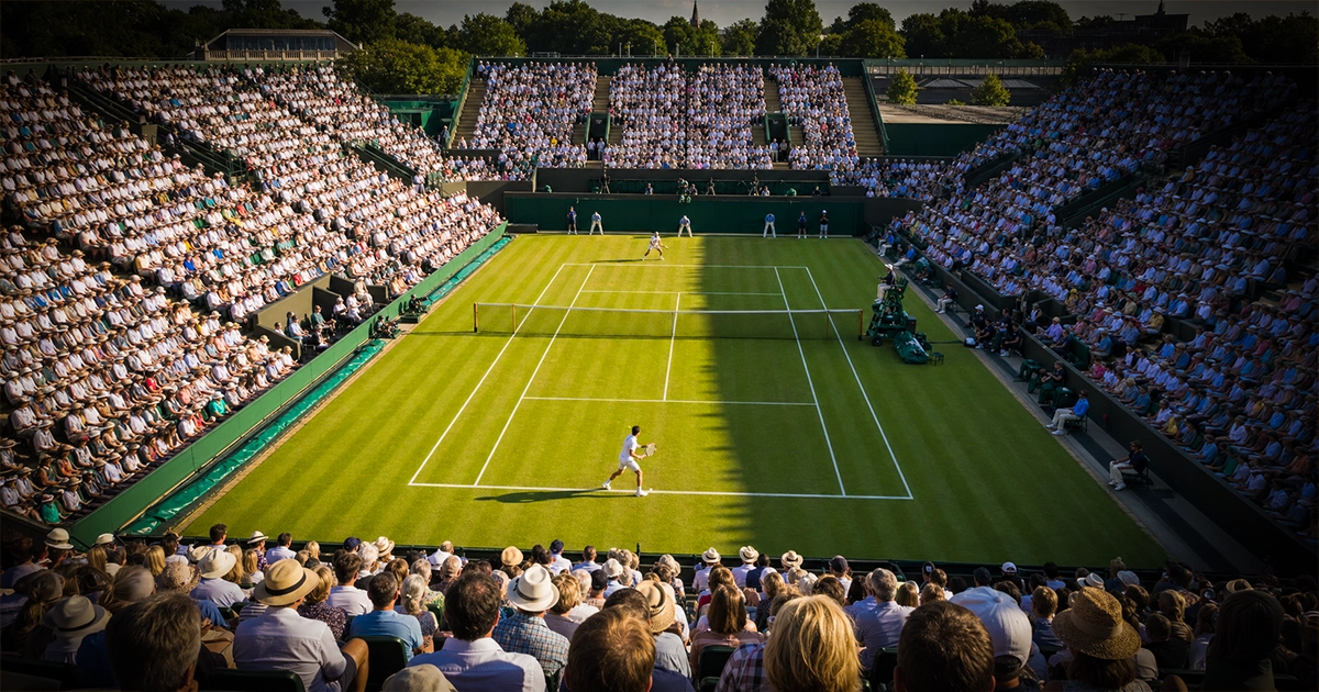 Centre Court at Wimbledon filled with spectators on a sunny summer afternoon